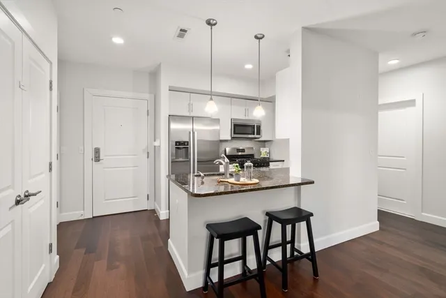 a kitchen with kitchen island a wooden floor and white appliances
