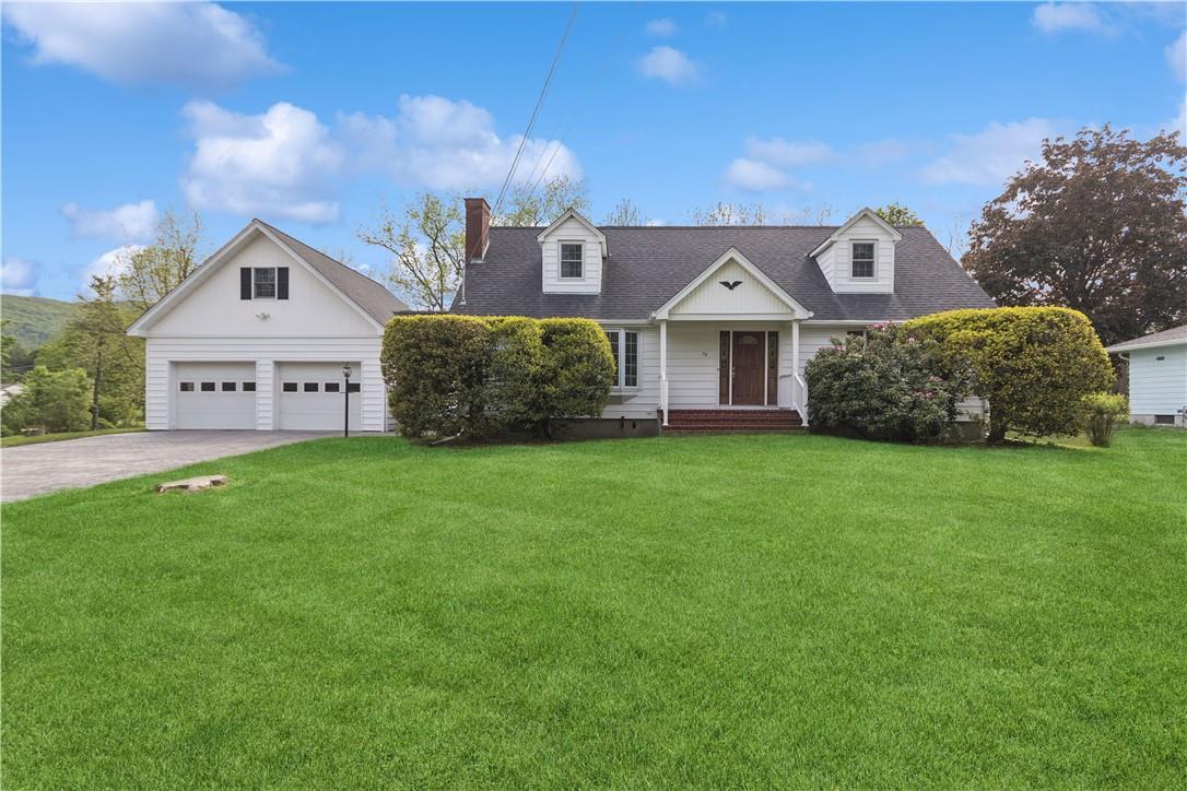 a front view of a house with a garden and yard