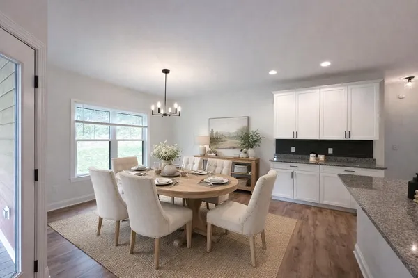 a kitchen with a dining table chairs and granite counter tops