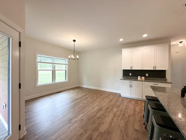 a kitchen with a refrigerator a stove a sink and a wooden floor