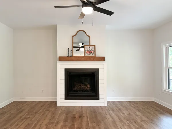 a living room with a fireplace and wooden floor