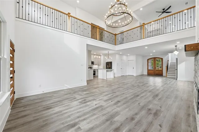 a view of a livingroom with wooden floor a fireplace window and a kitchen view