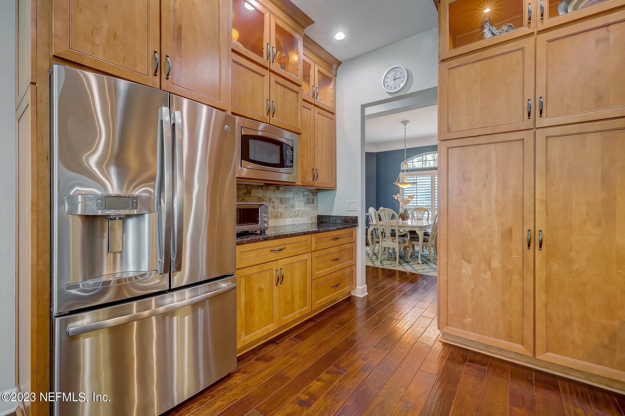 8026 Pine Lake Road Jacksonville, FL 32256 - Photo 11 of 43 a kitchen with stainless steel appliances granite countertop a refrigerator a microwave oven cabinets and wooden floor