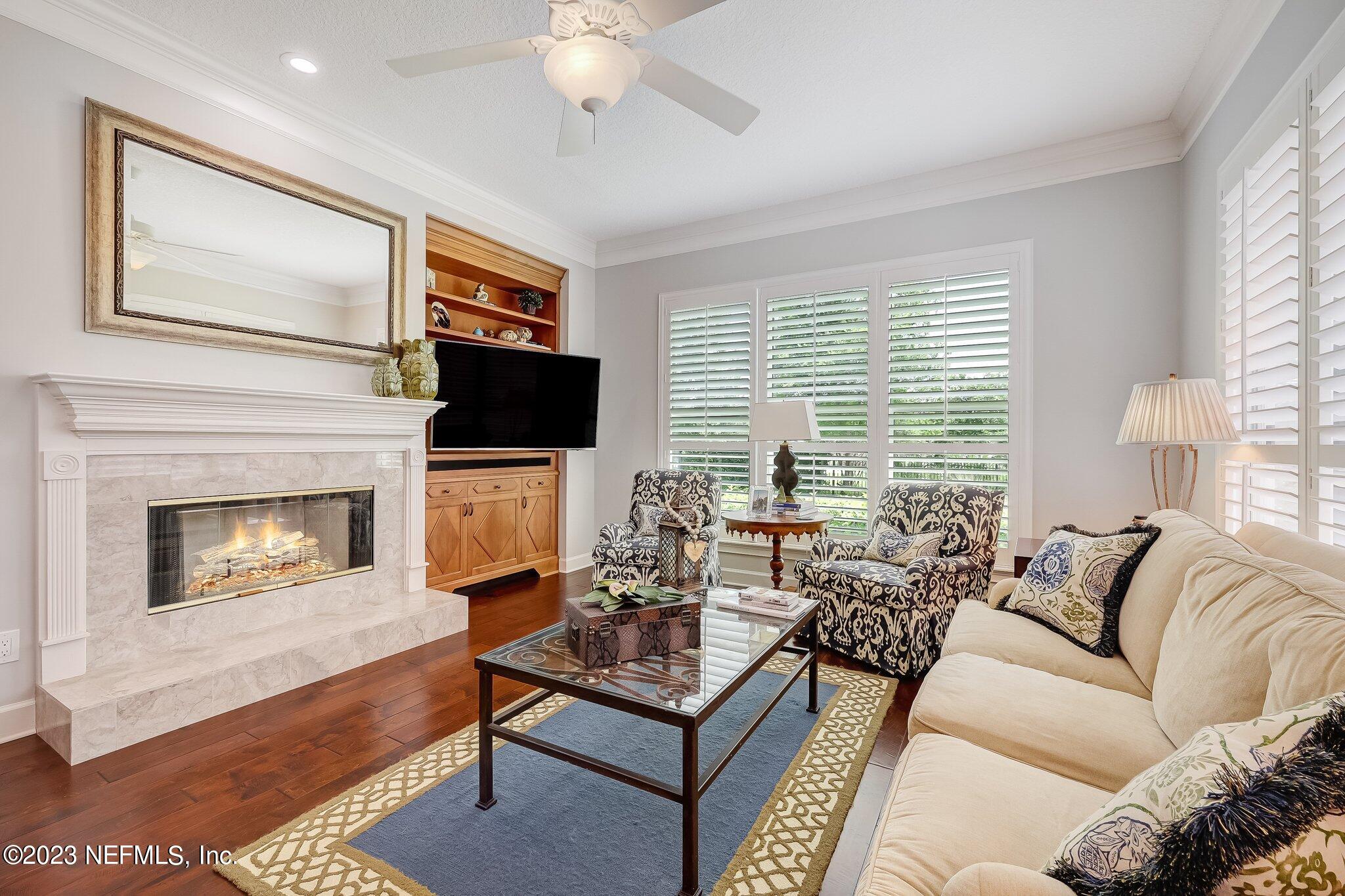 8026 Pine Lake Road Jacksonville, FL 32256 - Photo 18 of 43 a living room with furniture a flat screen tv and a fireplace