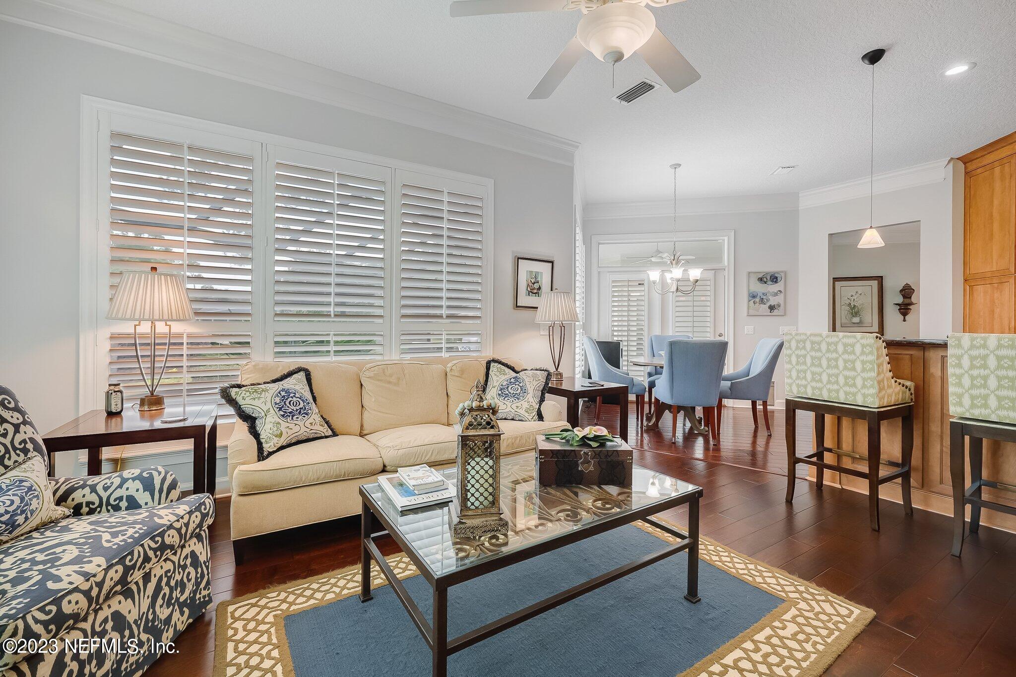 8026 Pine Lake Road Jacksonville, FL 32256 - Photo 20 of 43 a living room with furniture a wooden floor and a chandelier