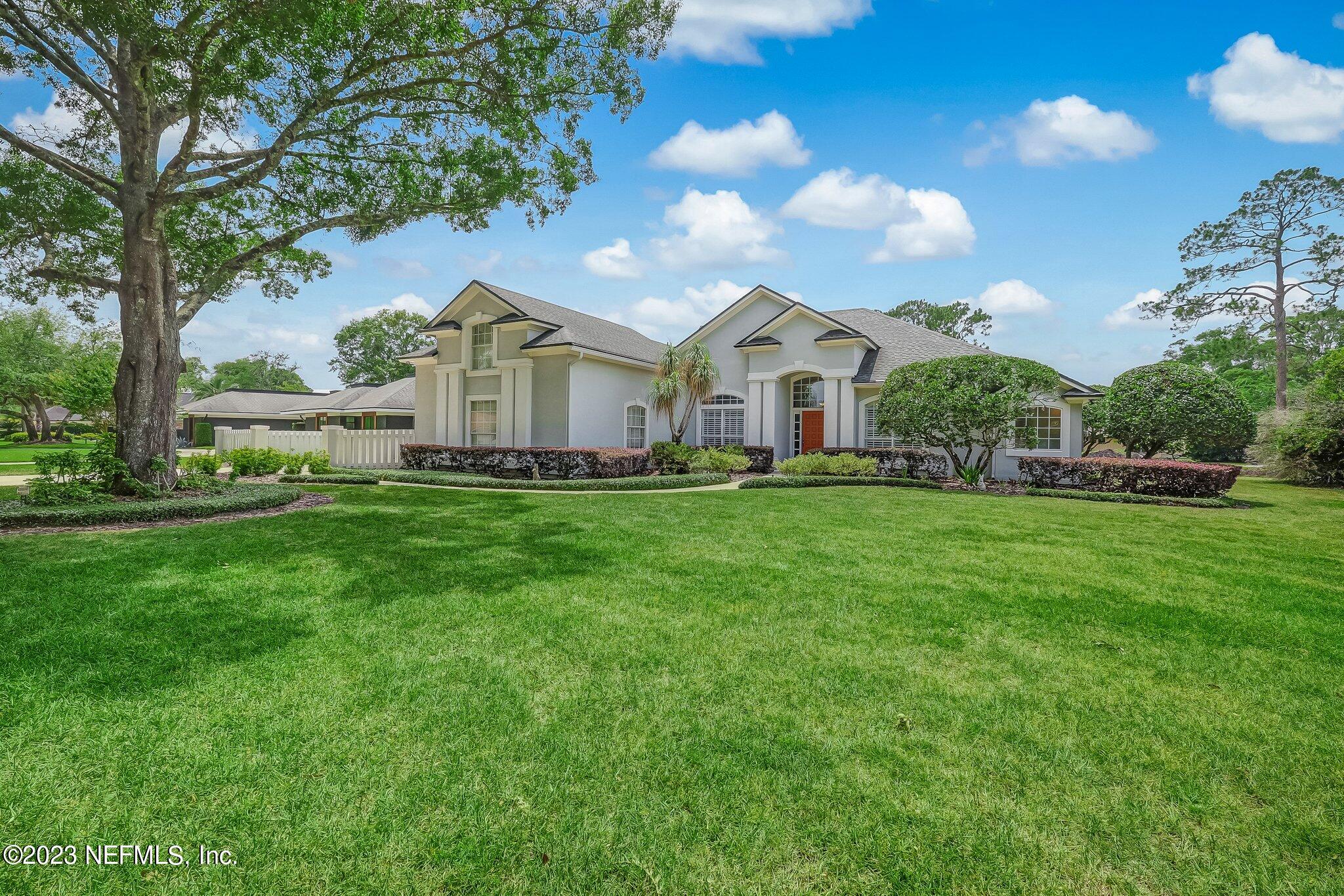 8026 Pine Lake Road Jacksonville, FL 32256 - Photo 2 of 43 a front view of a house with a garden and trees