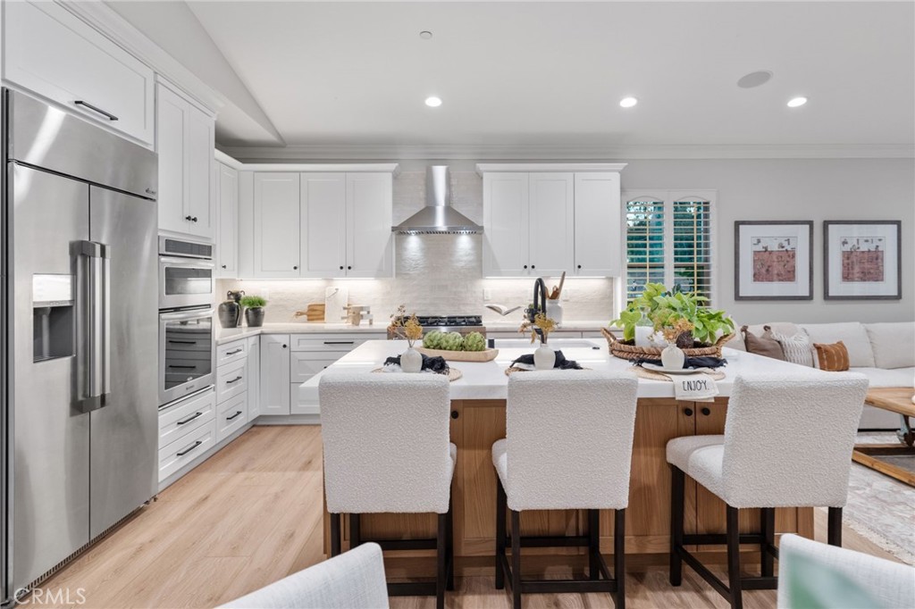 45 Shade Tree Irvine, CA 92603 - Photo 16 of 62 a kitchen with stainless steel appliances granite countertop a stove a refrigerator a kitchen island a dining table and chairs