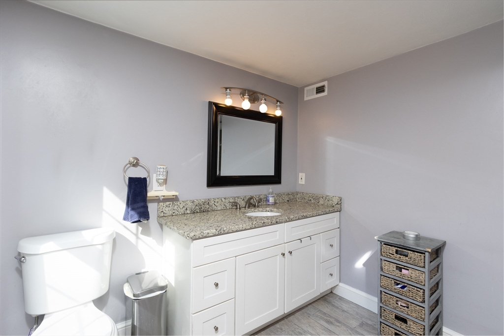 122 Wallace Road Sturbridge, MA 01566 - Photo 14 of 40 a bathroom with a granite countertop toilet sink and mirror