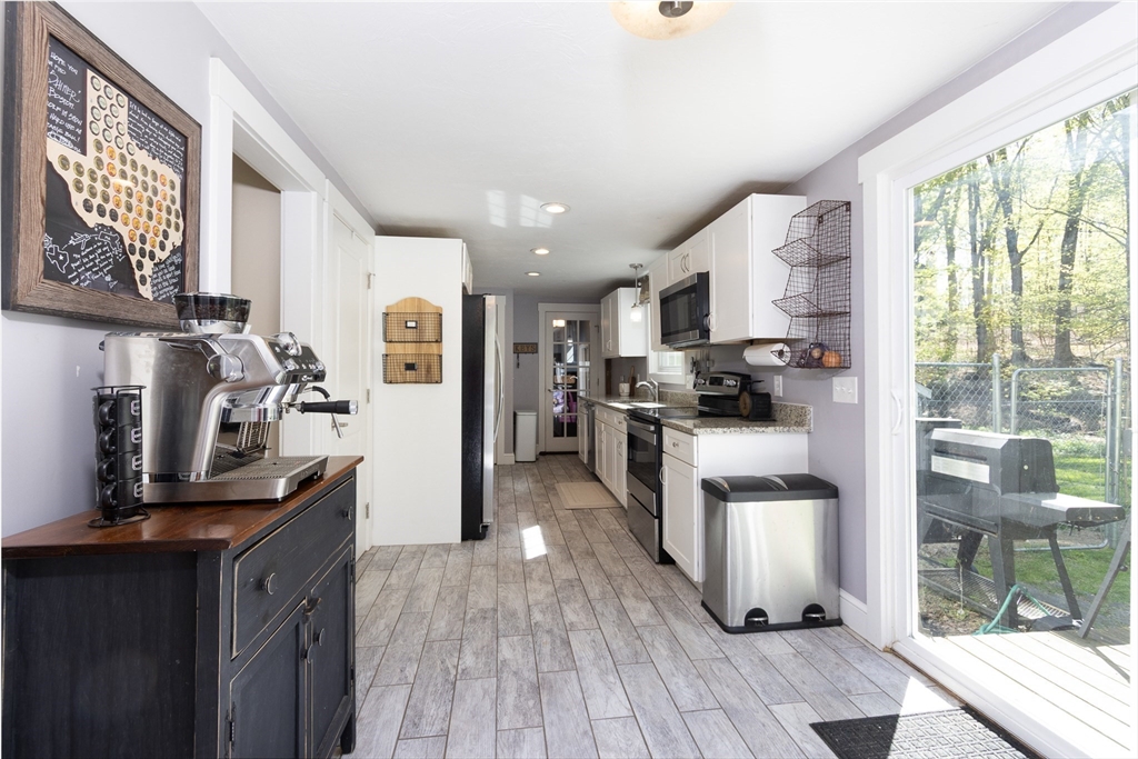 122 Wallace Road Sturbridge, MA 01566 - Photo 7 of 40 a kitchen with stainless steel appliances granite countertop a refrigerator a stove top oven a sink dishwasher and white cabinets with wooden floor