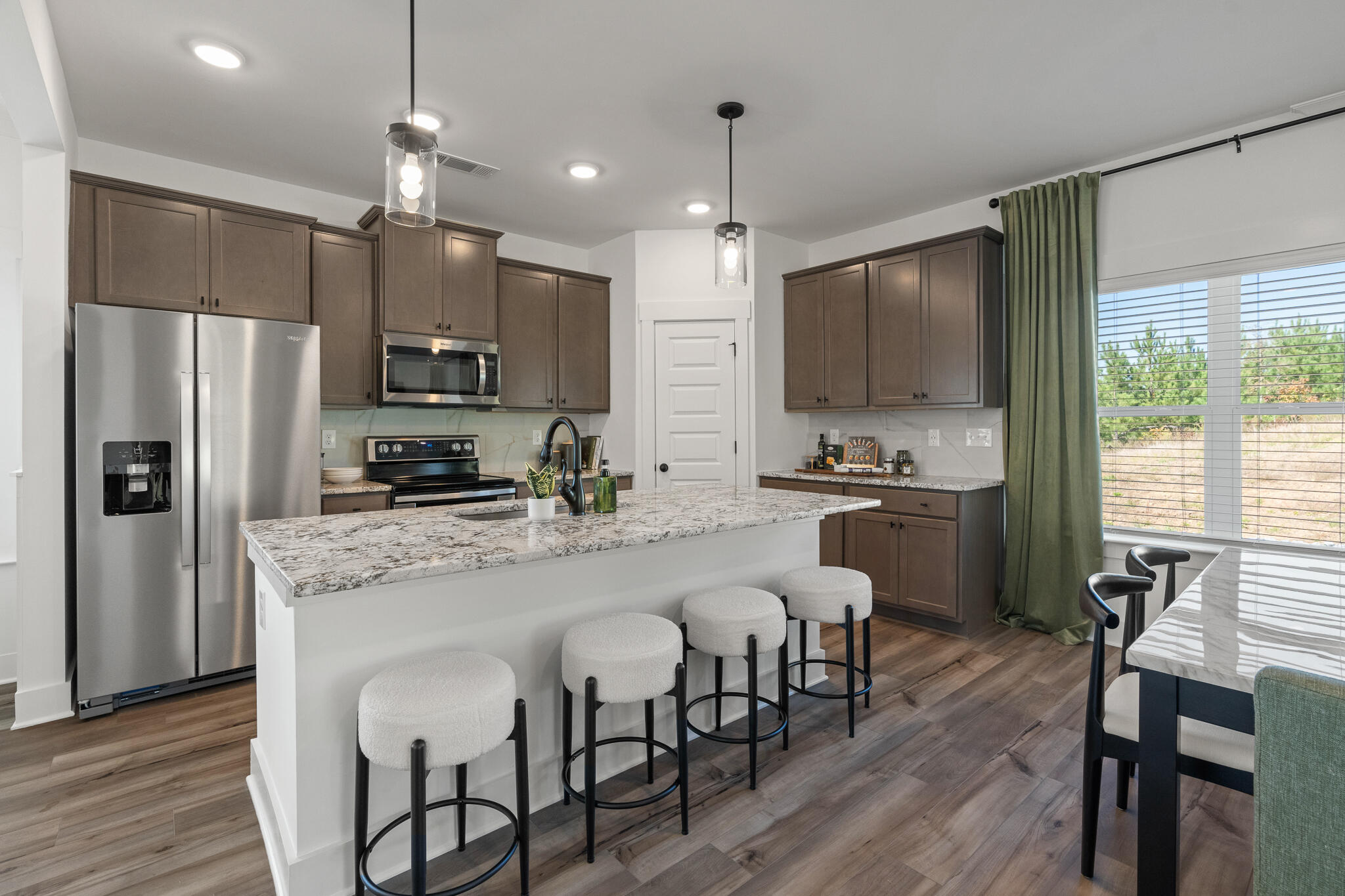 579 Bluebeech Street Freeport, FL 32439 - Photo 4 of 31 a large kitchen with kitchen island a dining table and chairs