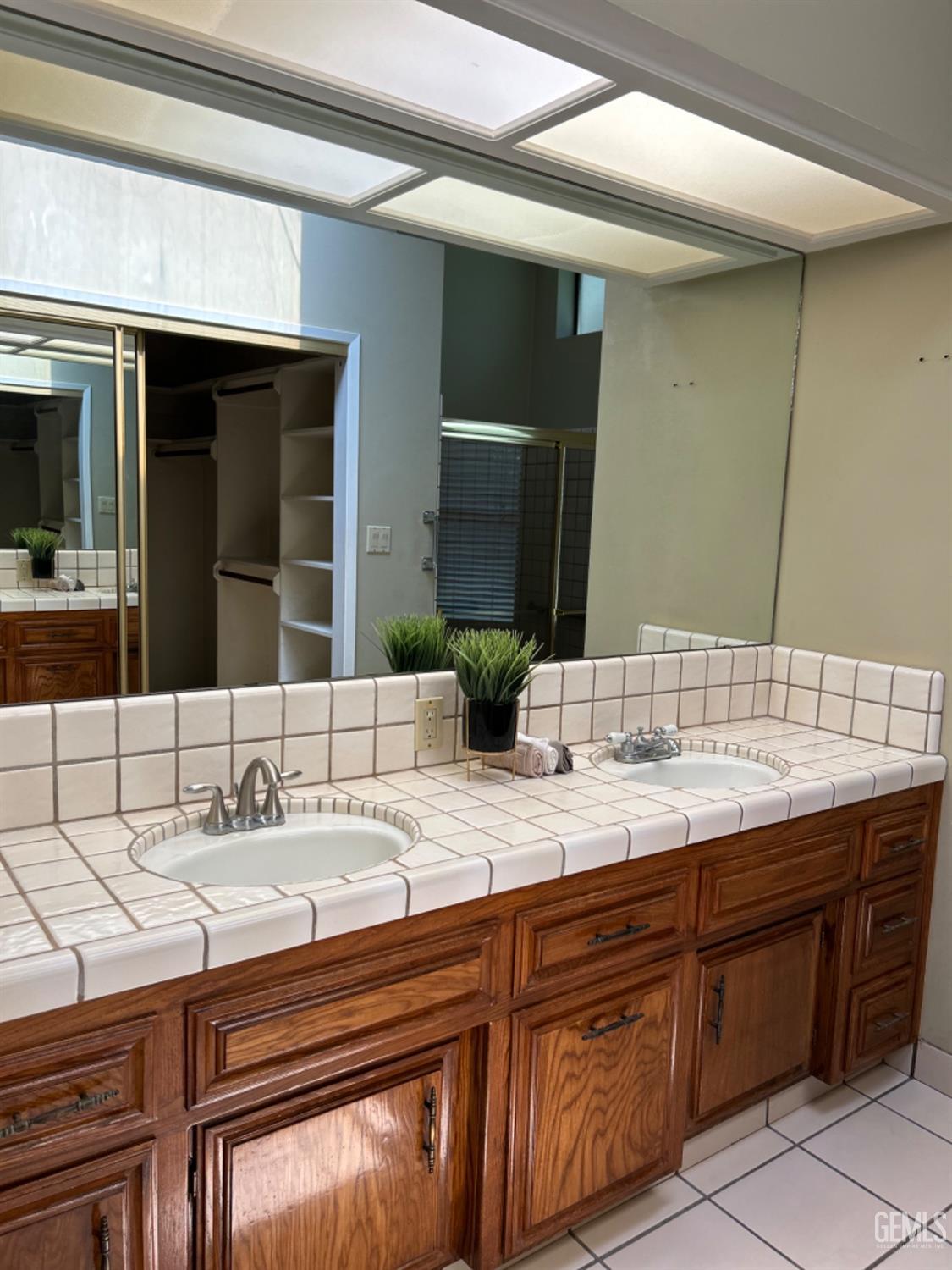 Undisclosed Address Bakersfield, CA 93309 - Photo 11 of 14 a bathroom with a double vanity sink and a mirror