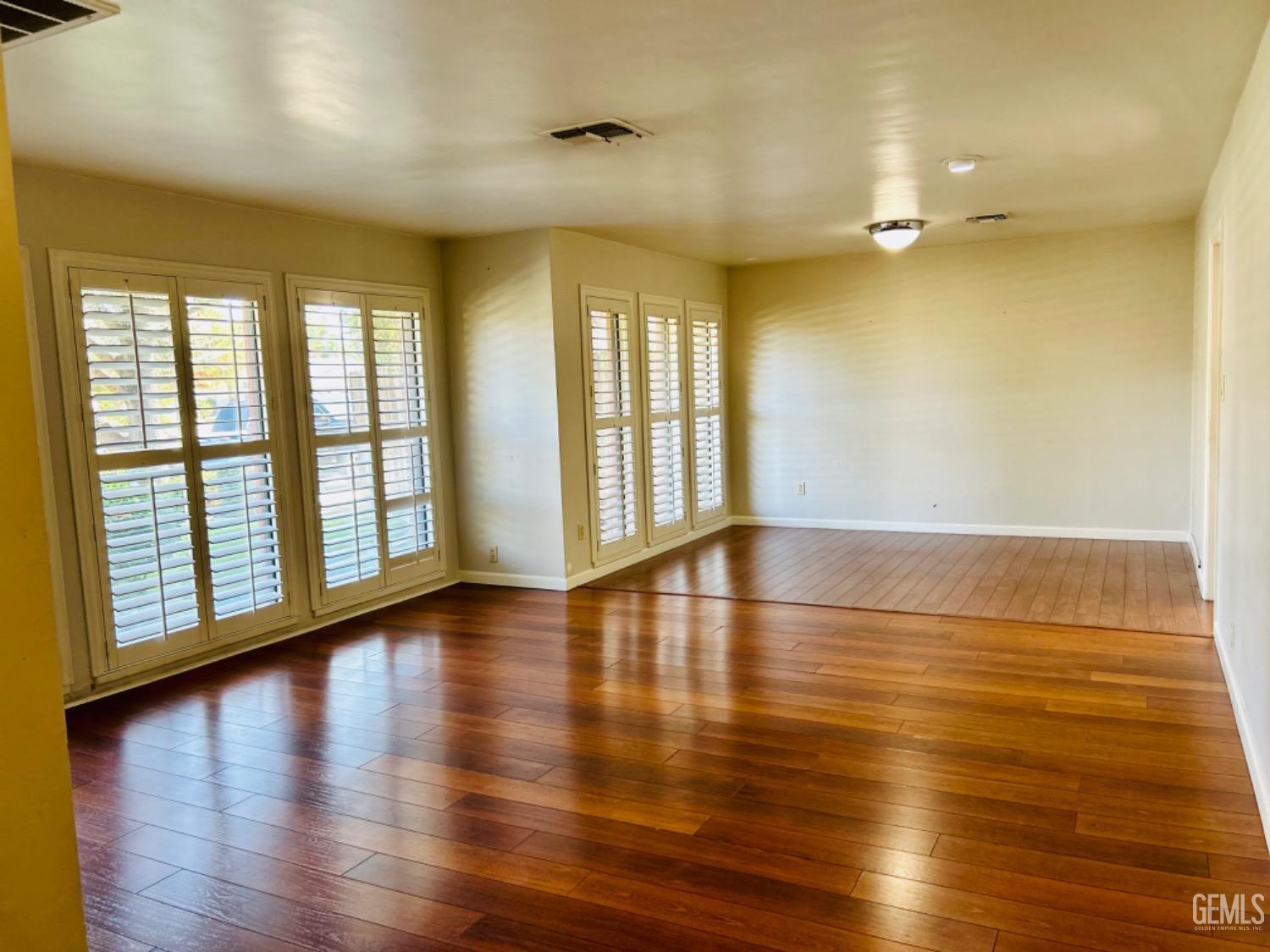 Undisclosed Address Bakersfield, CA 93309 - Photo 5 of 14 an empty room with wooden floor and windows