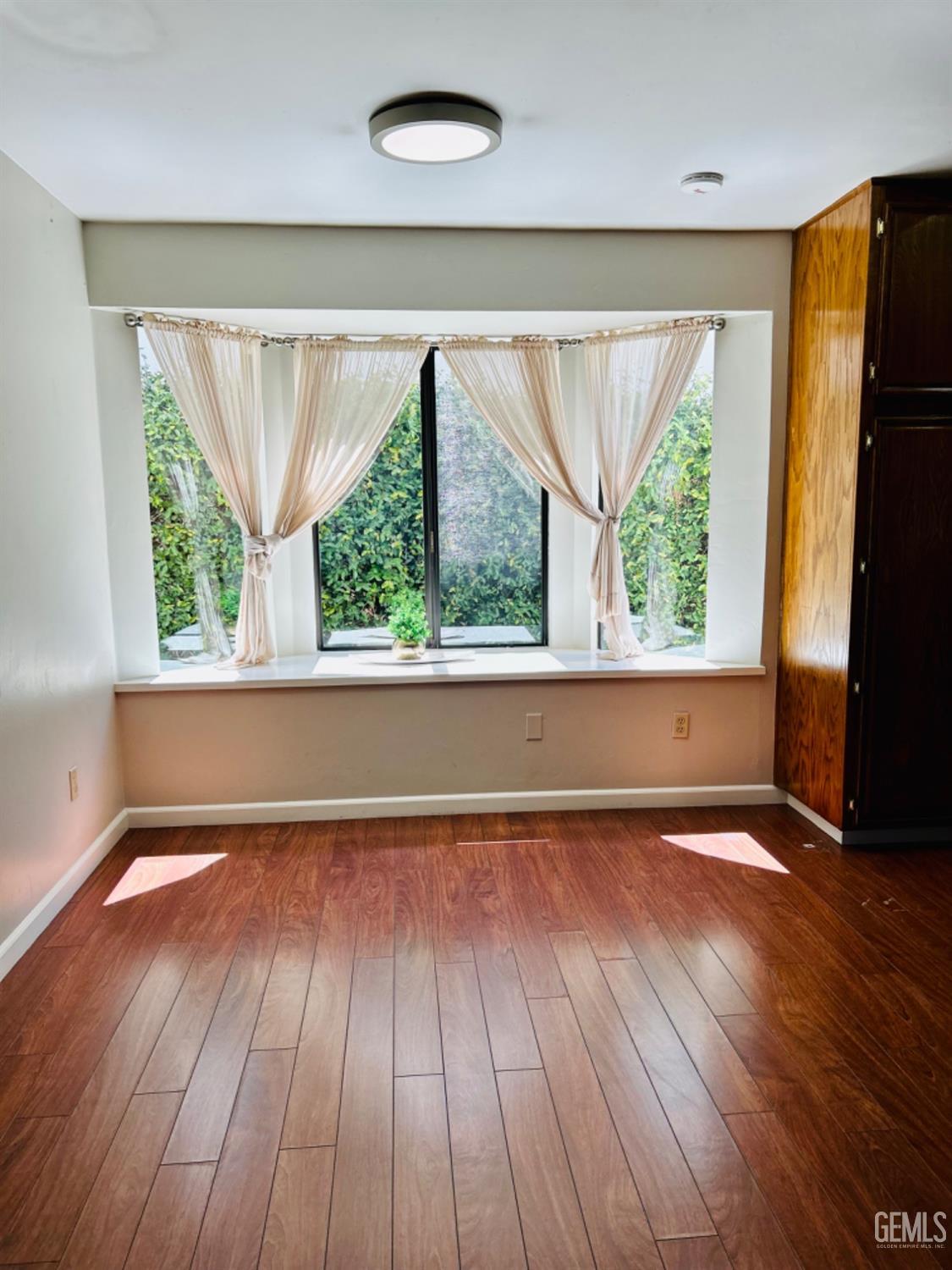 Undisclosed Address Bakersfield, CA 93309 - Photo 6 of 14 a view of an empty room with wooden floor and a window
