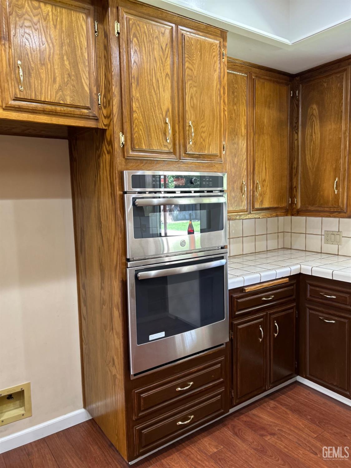 Undisclosed Address Bakersfield, CA 93309 - Photo 9 of 14 a kitchen with wooden cabinets and a stove top oven