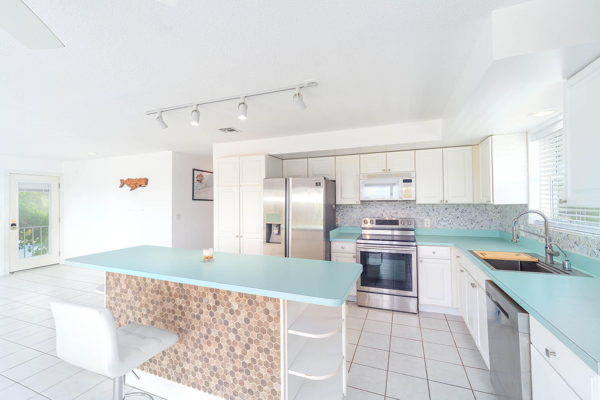 29849 Newfound Boulevard Big Pine Key, FL 33043 - Photo 8 of 25 a kitchen with stainless steel appliances kitchen island granite countertop a refrigerator and a sink