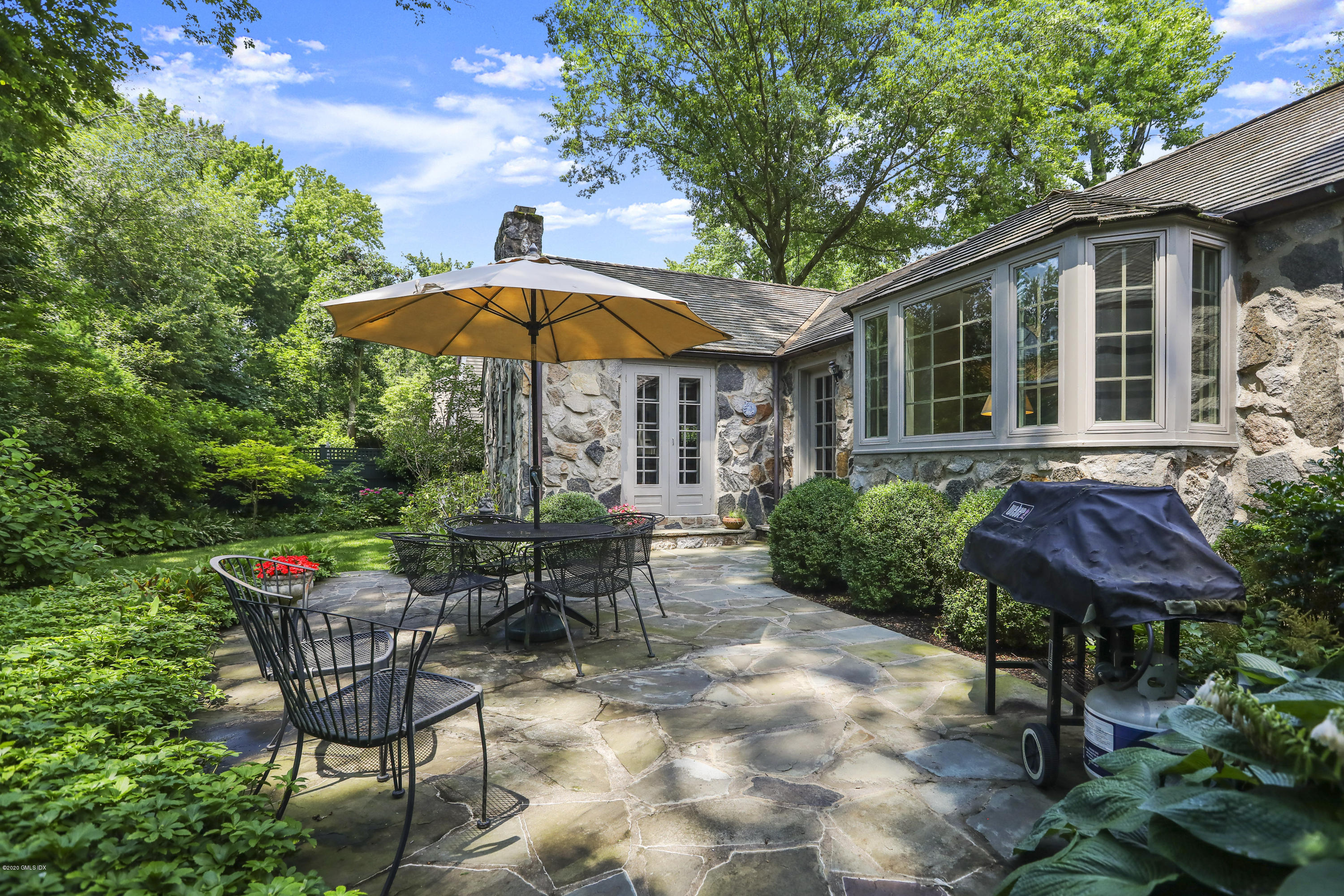14 Hidden Brook Road Riverside, CT 06878 - Photo 3 of 13 a view of a table and chairs under an umbrella in backyard