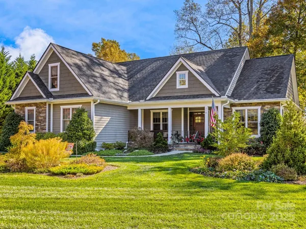 a front view of a house with swimming pool and porch with furniture