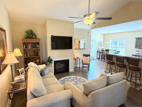 a living room with furniture a flat screen tv and a fireplace