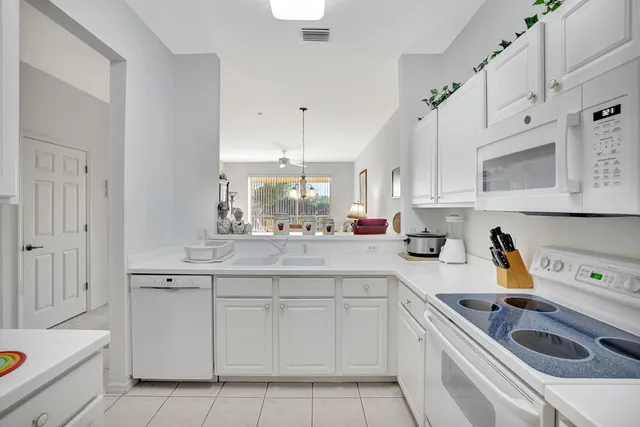 a kitchen with white cabinets and appliances