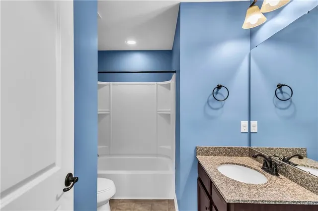 a bathroom with a granite countertop sink a mirror and shower