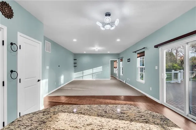 a view of a hallway with a dining table and a chandelier