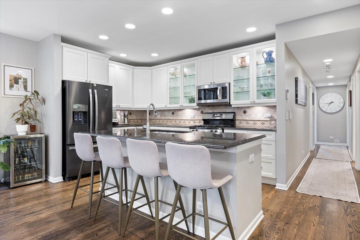1132 West Wolfram Street, Unit 3 Chicago, IL 60657 - Photo 8 of 26 a kitchen with stainless steel appliances granite countertop a stove a refrigerator a sink a stove a dining table and chairs