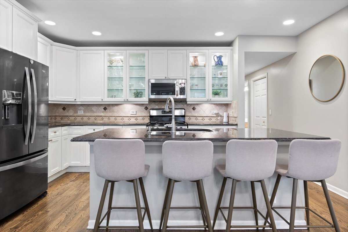 1132 West Wolfram Street, Unit 3 Chicago, IL 60657 - Photo 9 of 26 a kitchen with stainless steel appliances granite countertop a stove a sink a microwave a dining table and chairs