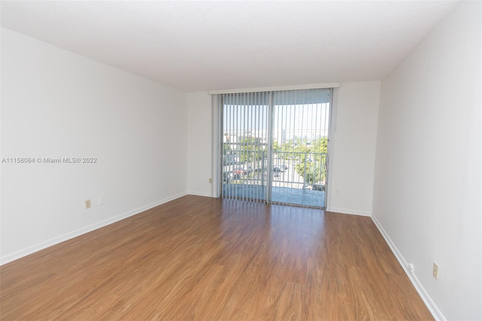 498 Northwest 165th Street, Unit D402 Miami, FL 33169 - Photo 1 of 3 an empty room with wooden floor and windows