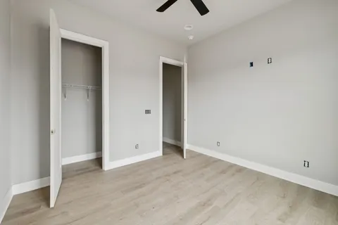 an empty room with closet and windows