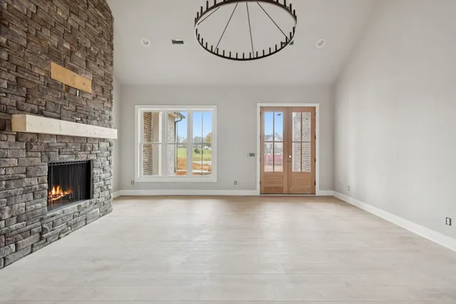 a view of an empty room with a fireplace and a window