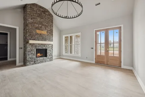 an empty room with windows and fireplace