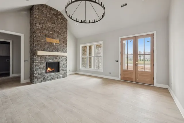 an empty room with windows and fireplace