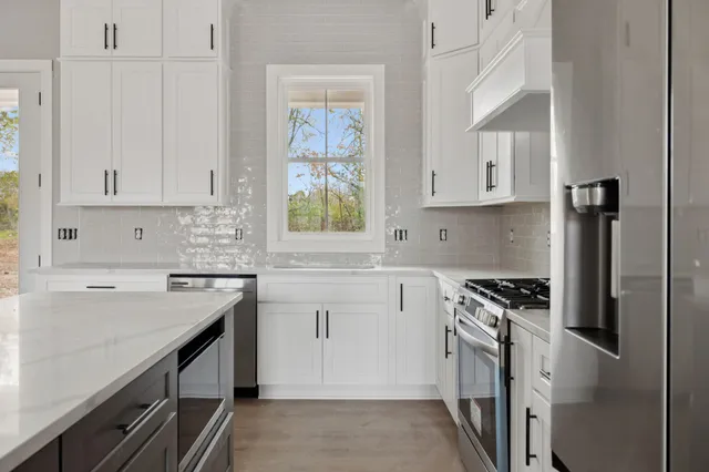 a kitchen with stainless steel appliances a sink stove and cabinets