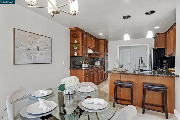 a kitchen with stainless steel appliances a dining table and chair