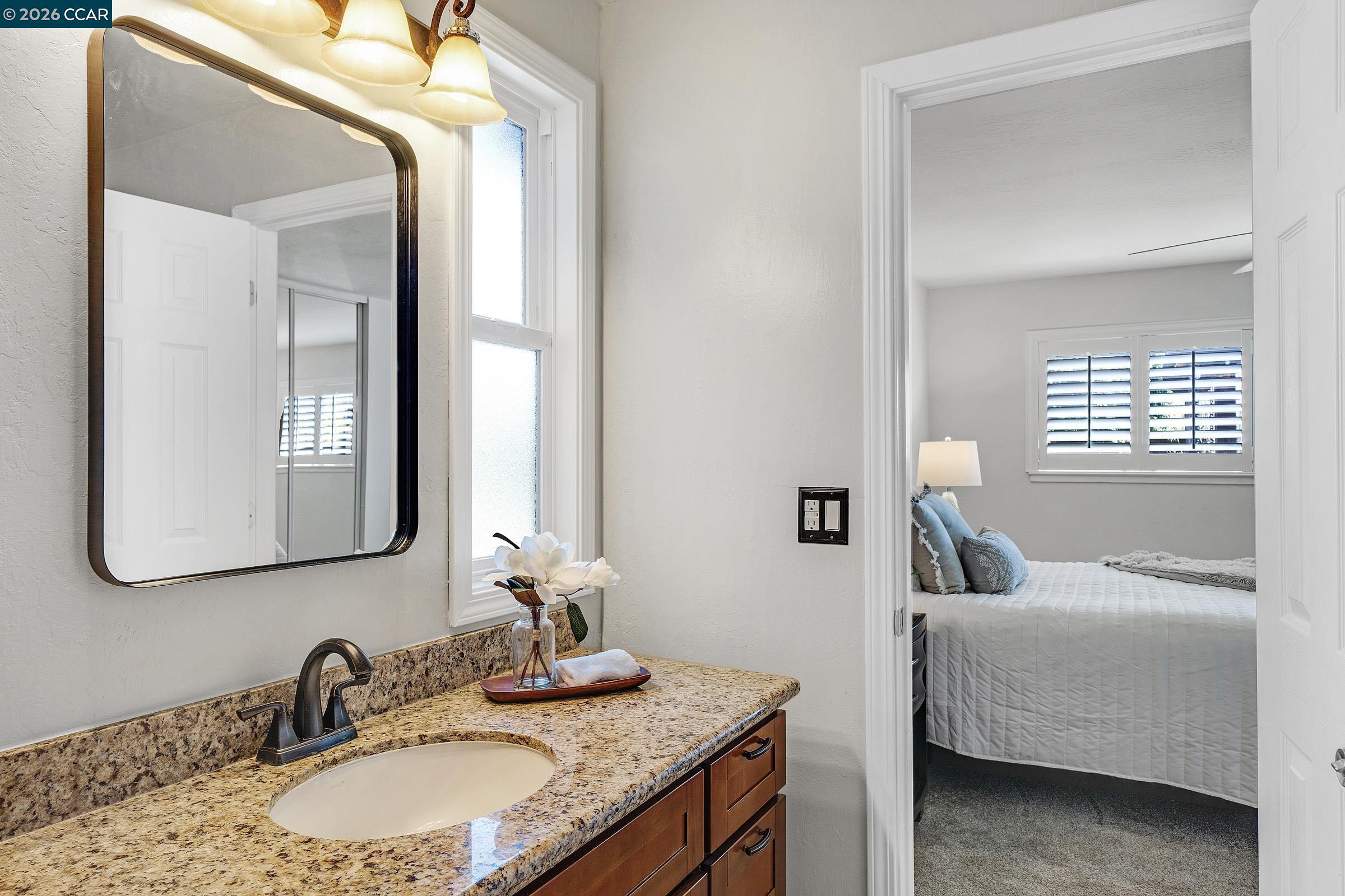 2415 Crestline Road Pleasanton, CA 94566 - Photo 17 of 40 a en suite bathroom with a granite countertop sink and a mirror