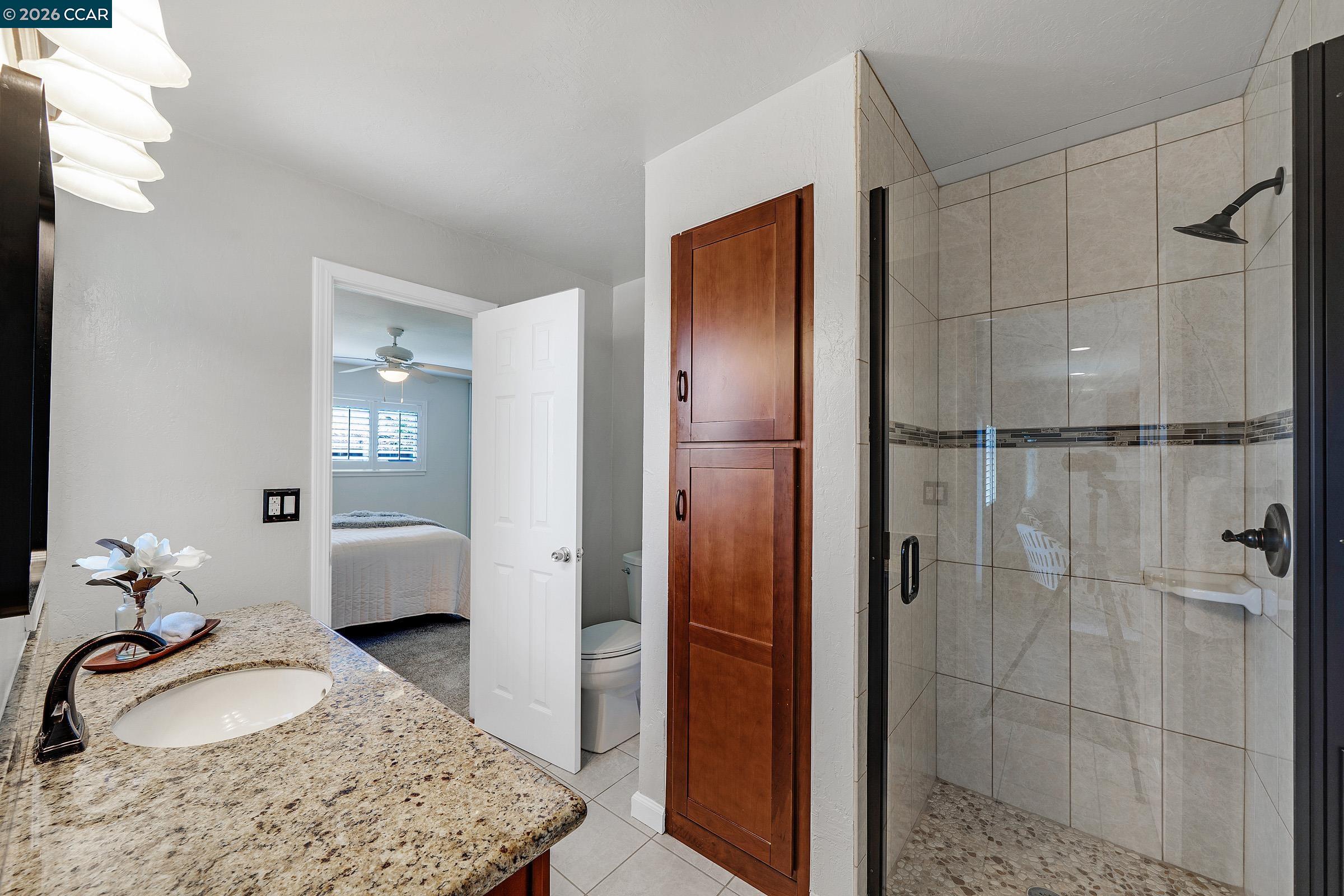 2415 Crestline Road Pleasanton, CA 94566 - Photo 18 of 40 a en suite bathroom with a granite countertop sink and a mirror