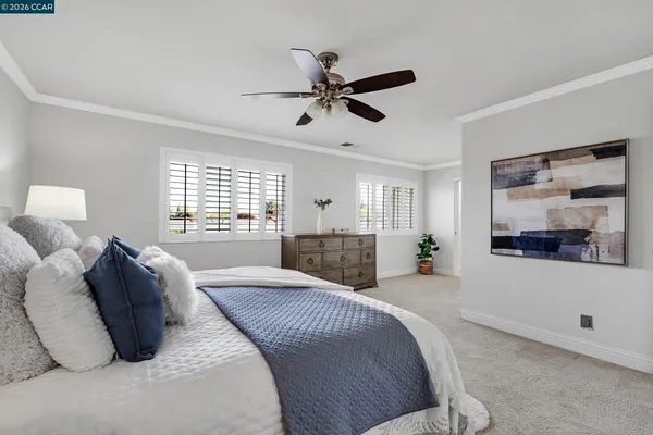 a spacious bedroom with a bed a window and a couch
