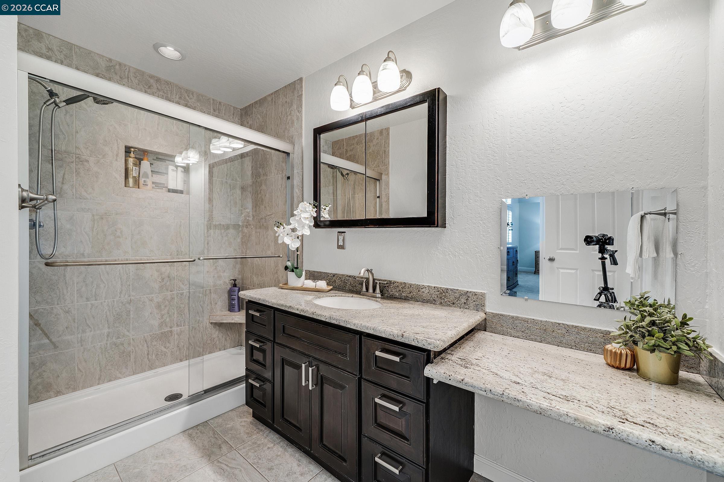 2415 Crestline Road Pleasanton, CA 94566 - Photo 28 of 40 a bathroom with a granite countertop sink a mirror and a shower