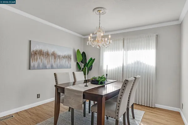 a dining room with furniture a chandelier and wooden floor
