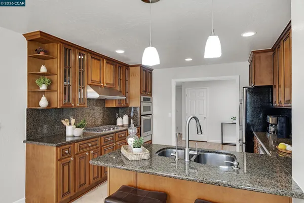 a kitchen with granite countertop a sink stainless steel appliances and cabinets
