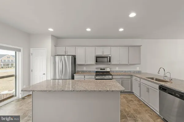 a kitchen with stainless steel appliances a sink stove and refrigerator