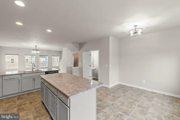 a kitchen with granite countertop a sink stove and refrigerator
