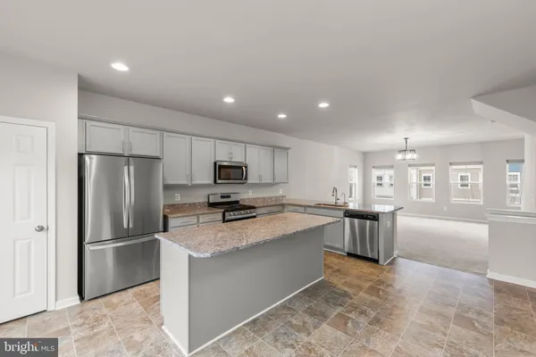 a kitchen with stainless steel appliances granite countertop a refrigerator sink and stove