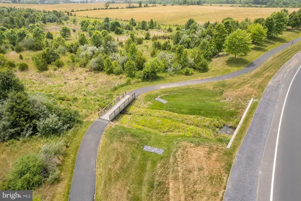 an aerial view of residential houses with outdoor space and trees