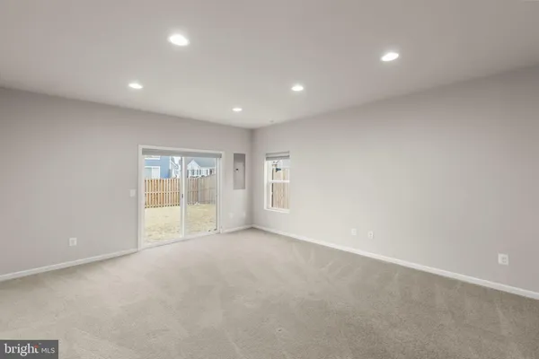 a view of an empty room with glass door and windows