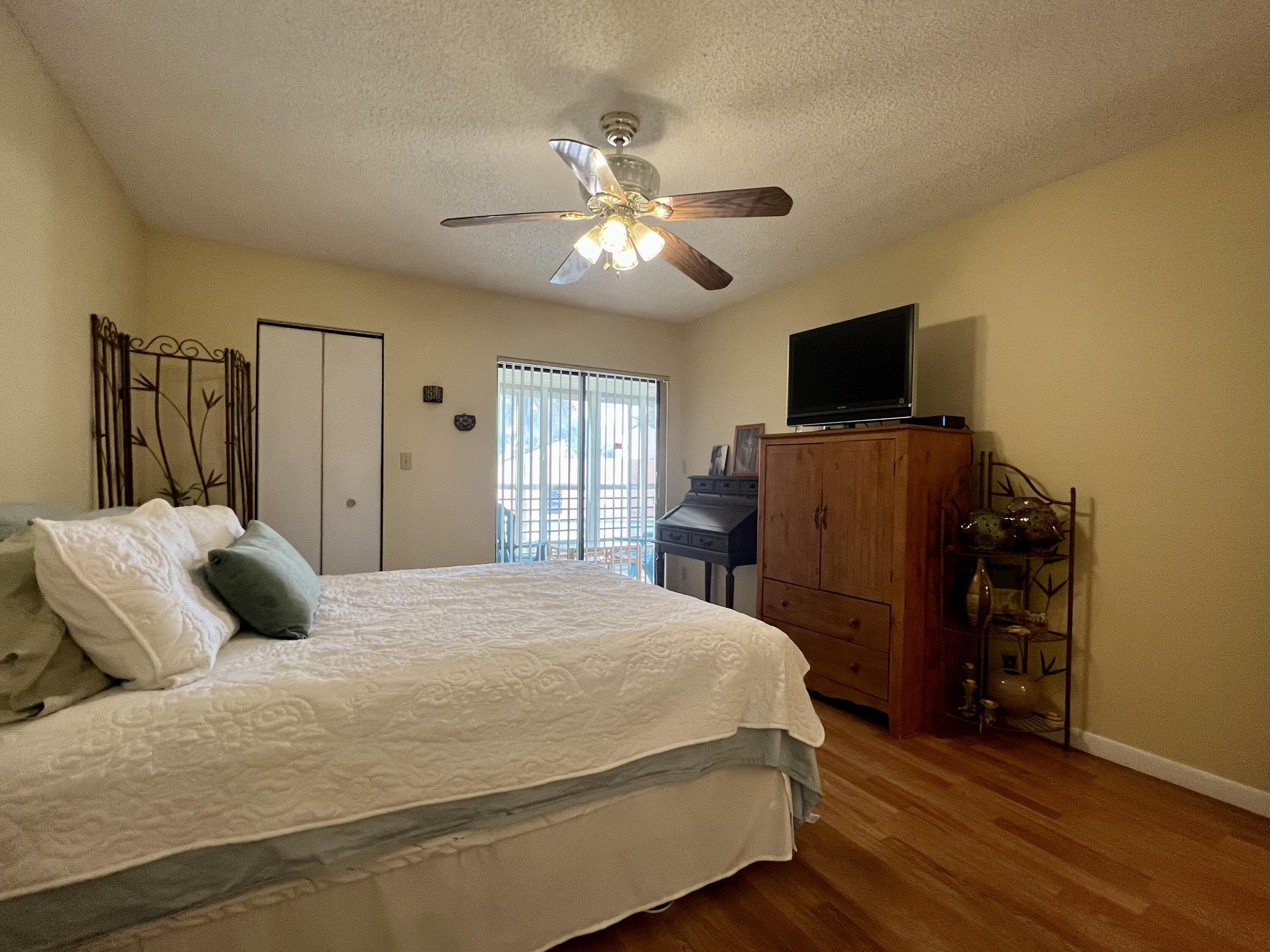 3154 Via Poinciana, Unit 214 Lake Worth, FL 33467 - Photo 11 of 23 a bedroom with a bed and a flat screen tv
