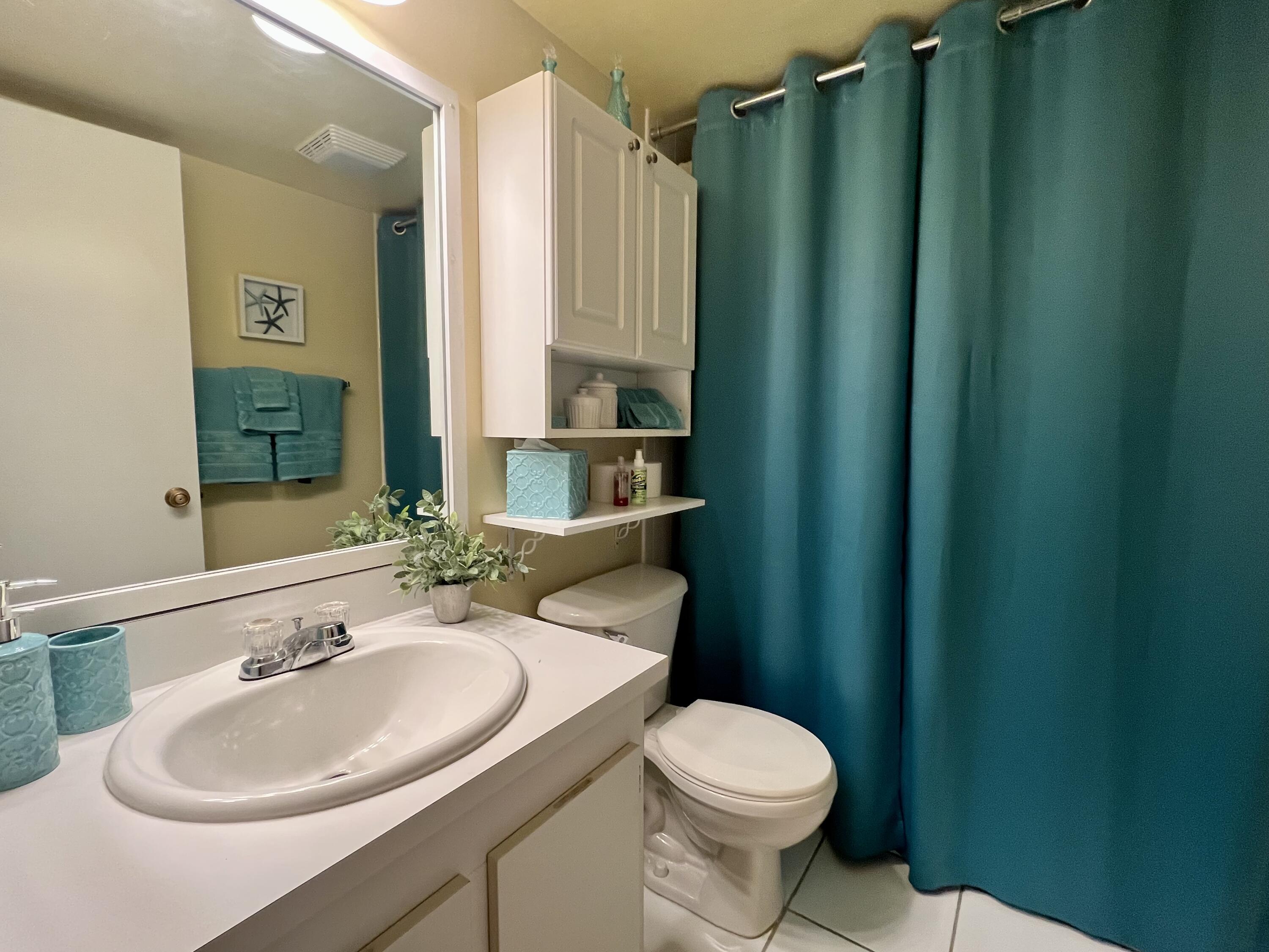 3154 Via Poinciana, Unit 214 Lake Worth, FL 33467 - Photo 15 of 23 a bathroom with a sink a toilet and shower