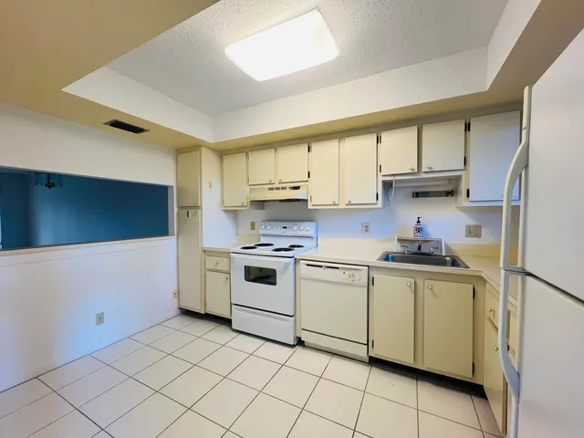 a kitchen with a stove sink and cabinets