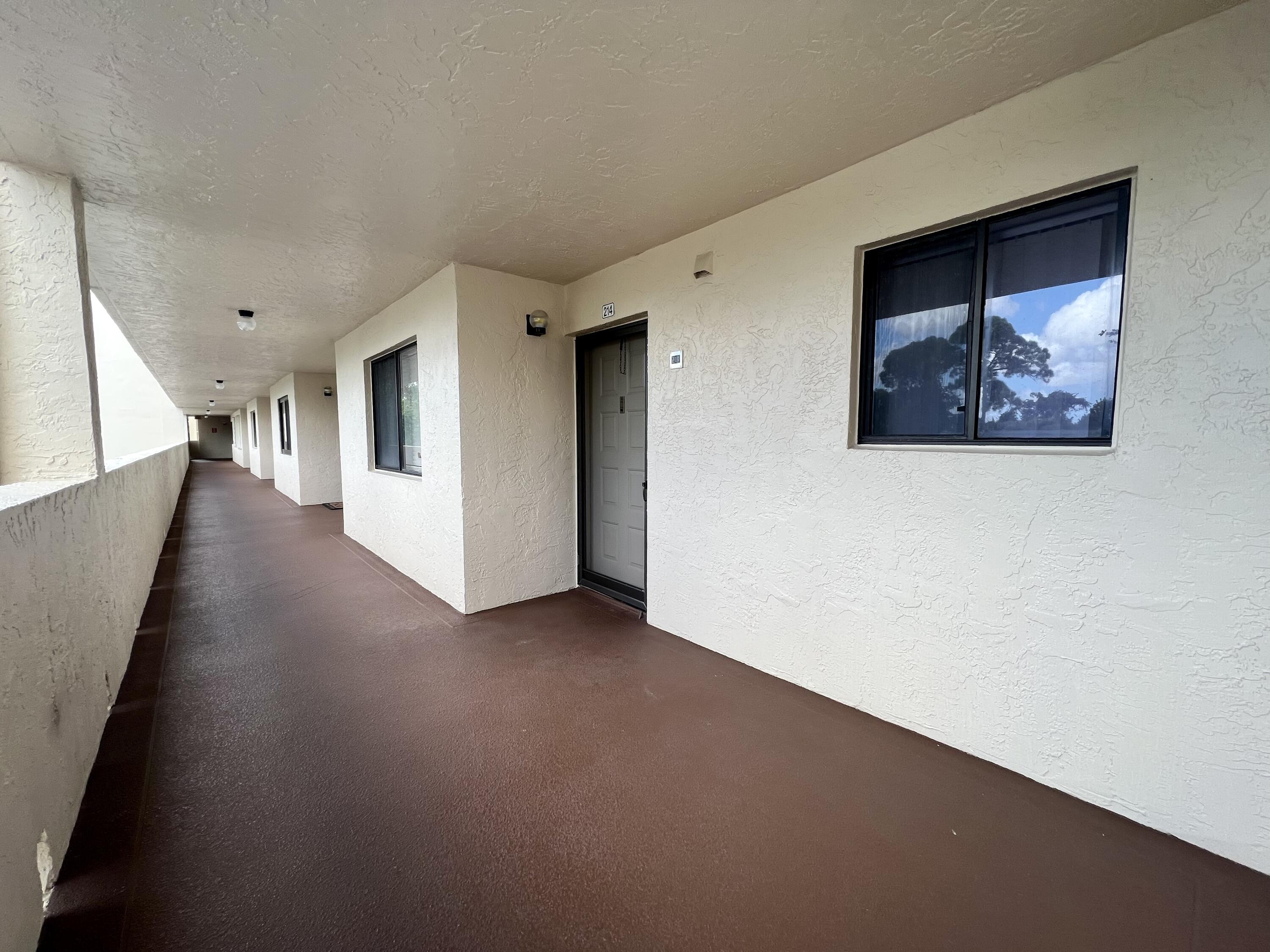 3154 Via Poinciana, Unit 214 Lake Worth, FL 33467 - Photo 22 of 23 a view of a hallway with staircase