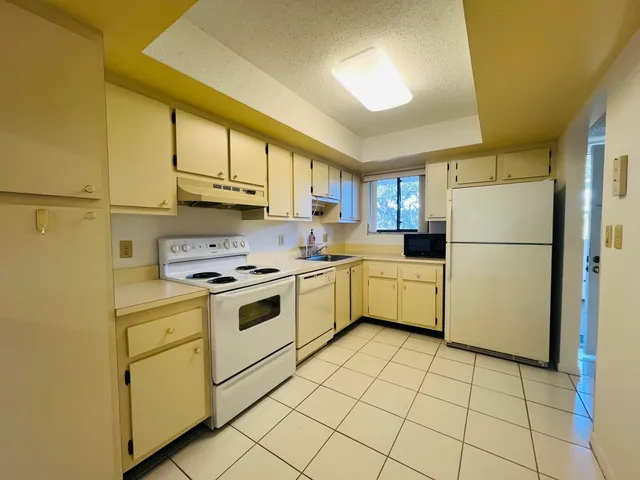 a kitchen with a white cabinets and white appliances